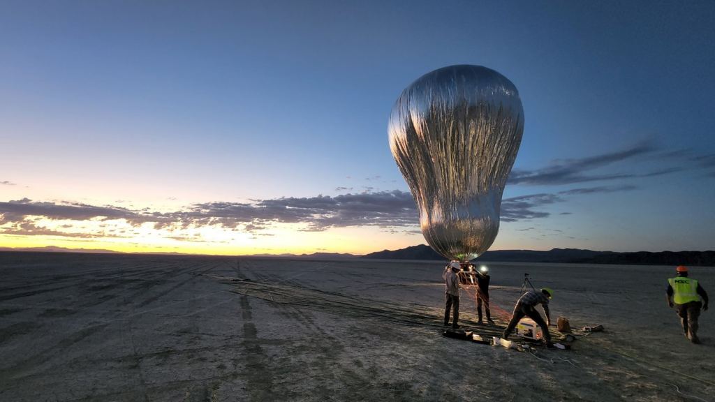 A prototype aerial robotic balloon, or aerobot, is readied for a dawn test flight in Black Rock Desert, Nevada, in July 2022, by team members from JPL and Near Space Corporation.  The aerobot successfully completed two flights, demonstrating controlled altitude flight.  Credit: NASA/JPL-Caltech