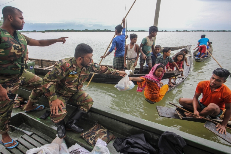 Soldiers deliver food aid to affected families in flooded residential areas following heavy monsoon rains in Goyainghat on June 23, 2022