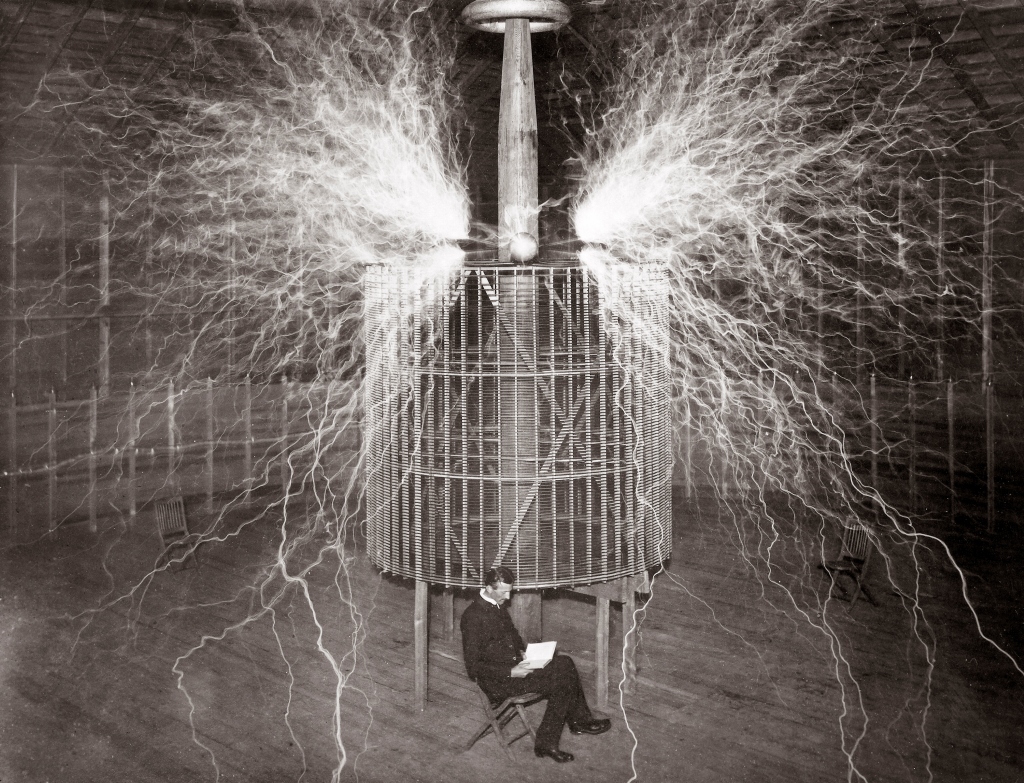 Nikola Tesla (1856-1943), Serbian-American physicist sitting in his Colorado Springs laboratory with his 