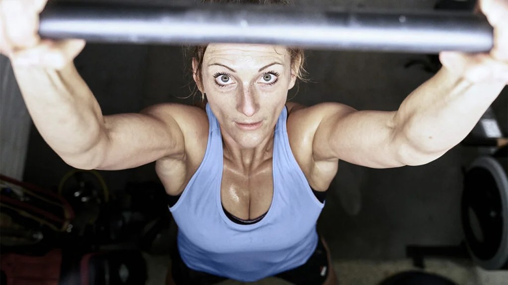 An overhead close-up of a woman lifting a barbell