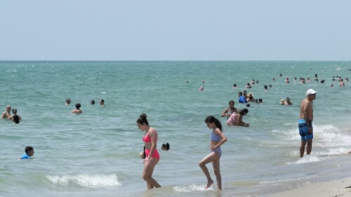 Beachgoers take a dip in the Atlantic Ocean at Hollywood Beach, Monday, July 10, 2023, in Hollywood, Fla. adding a little more crap to the state's already oppressive summer weather.  (AP Photo/Wilfredo Lee)