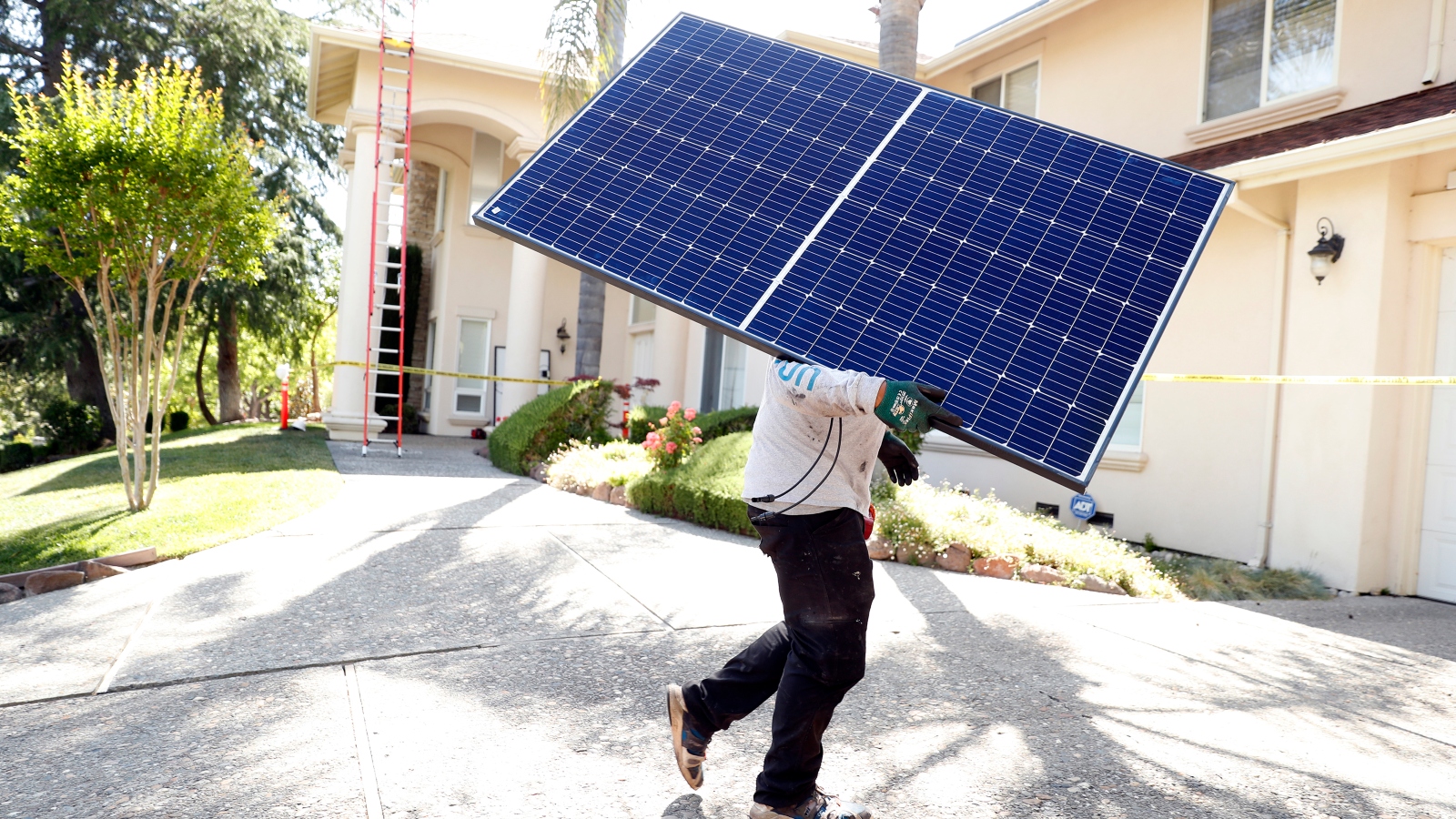 Sunrun employee Gonzalo Najera carries a solar panel before installation at a home in Alamo, Calif. on Monday, May 17, 2021.