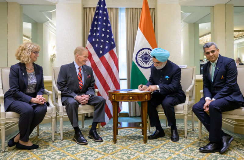 Taranjit Sandhu, Indian ambassador to the United States, signs the Artemis Accords in Washington on June 21.  NASA Administrator Bill Nelson watches from across the table.